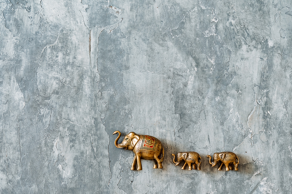 bronze sculpture of an adult elephants followed by his infants