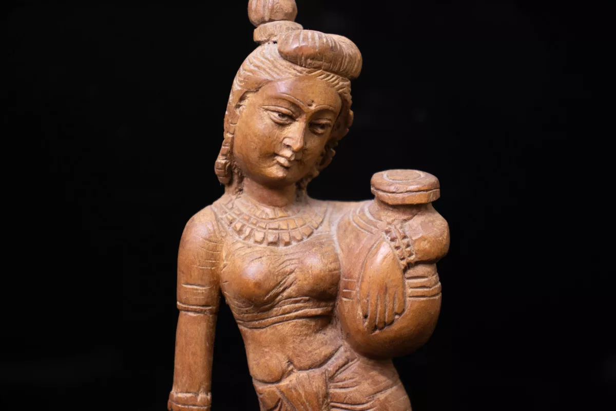 Wooden Sculpture of a lady holding a pot on her waist